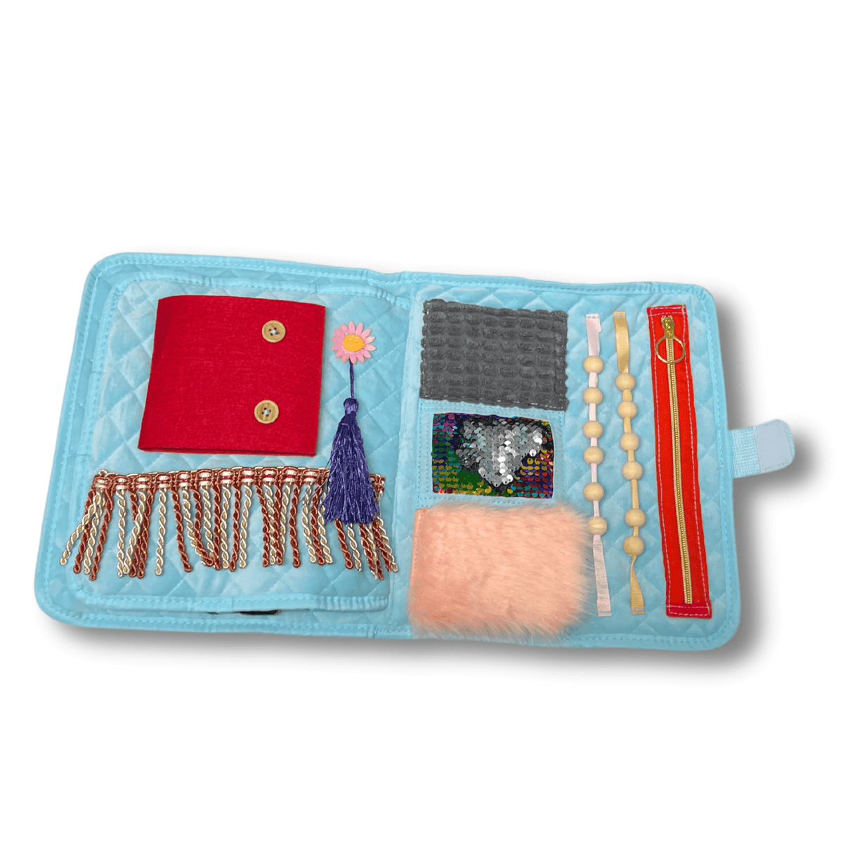 Fikleteppets andre side med rød lomme med knapper, frynser, perlesnorer, pelsbit og et stoff med paljetter